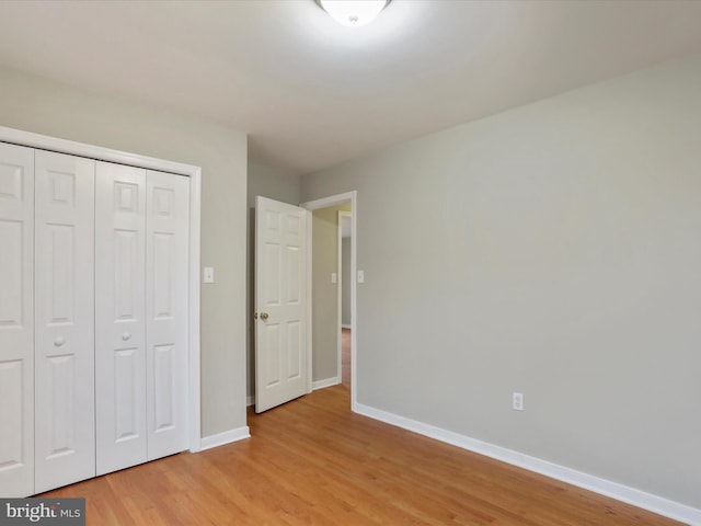 unfurnished bedroom featuring light hardwood / wood-style floors and a closet