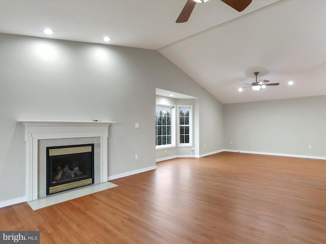 unfurnished living room with ceiling fan, wood-type flooring, and vaulted ceiling