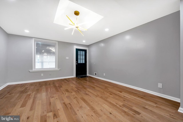 entrance foyer with light hardwood / wood-style flooring and a skylight