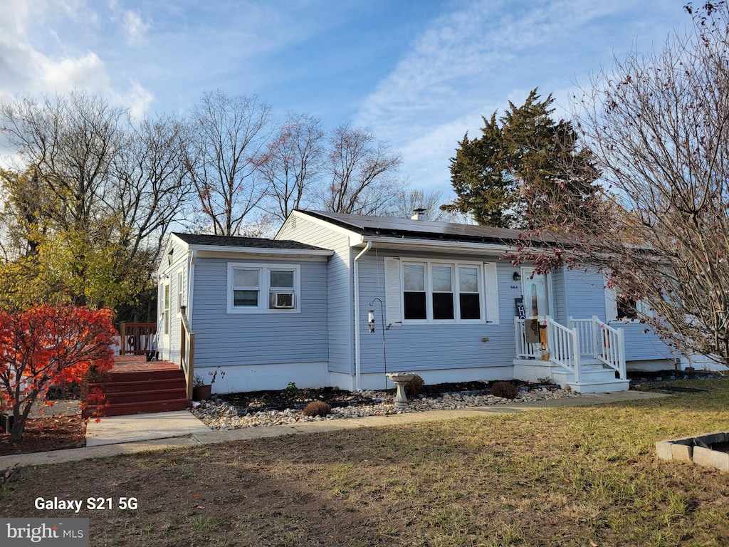 view of front of house featuring a front yard and solar panels