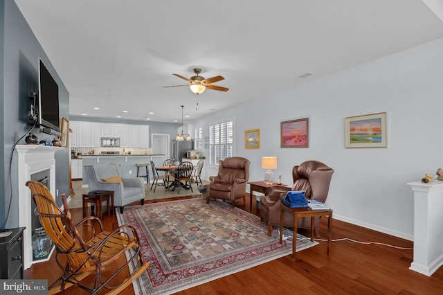 living room with ceiling fan and hardwood / wood-style flooring