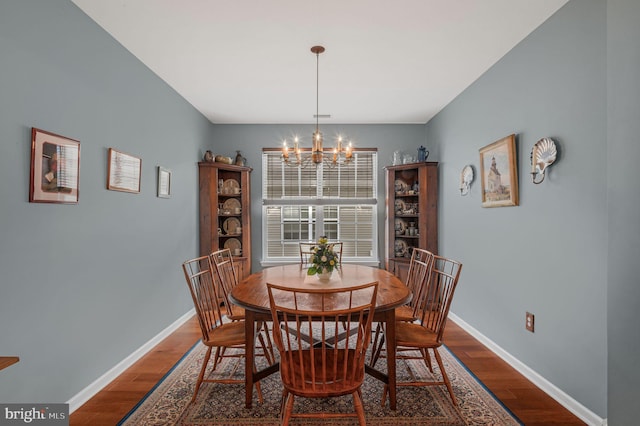 dining room with wood-type flooring and a notable chandelier