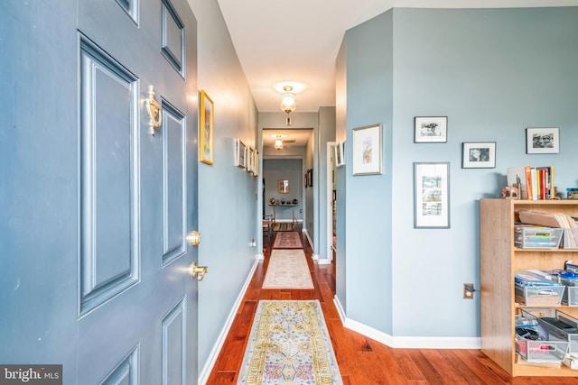 corridor with hardwood / wood-style flooring