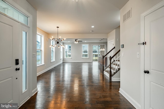 entryway with ceiling fan with notable chandelier and dark hardwood / wood-style floors