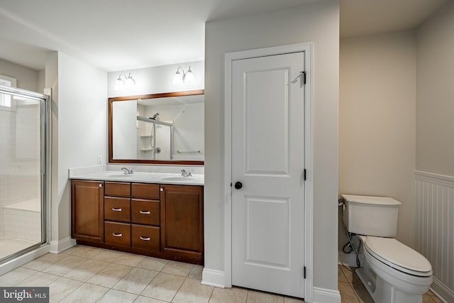 bathroom with tile patterned floors, vanity, toilet, and walk in shower