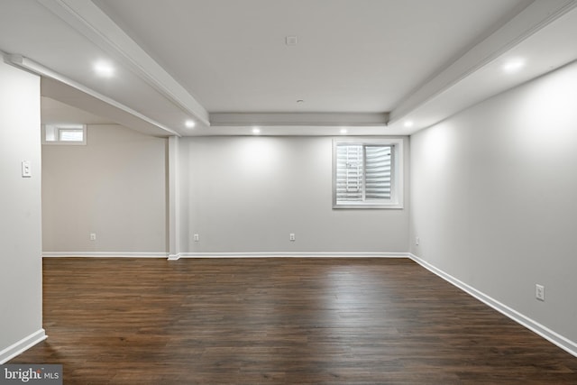 spare room with dark hardwood / wood-style flooring and a tray ceiling