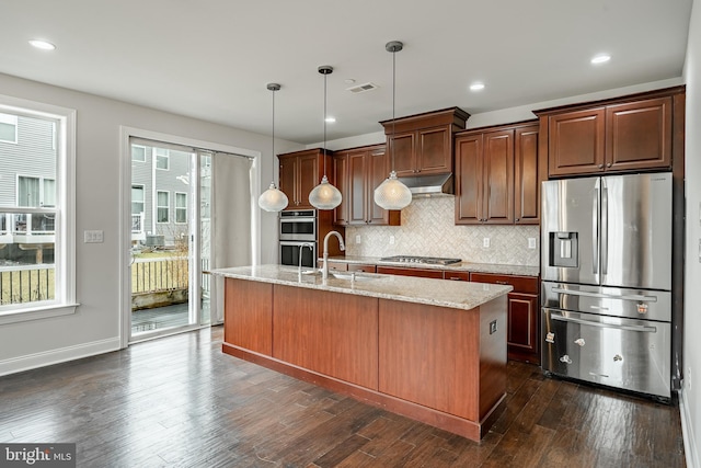 kitchen with stainless steel appliances, plenty of natural light, a center island with sink, and sink