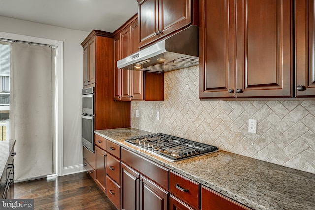 kitchen featuring backsplash, dark hardwood / wood-style floors, light stone countertops, and stainless steel appliances