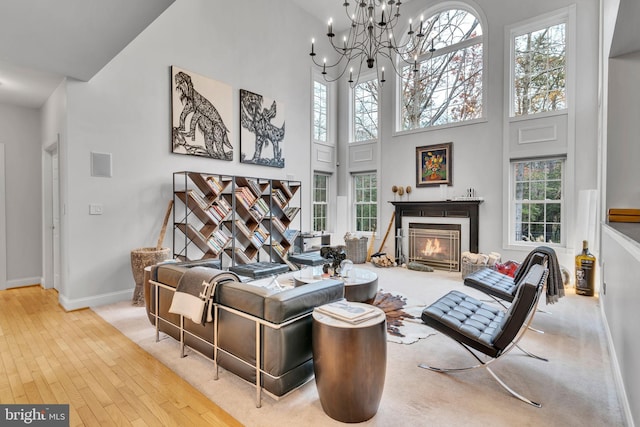 216 Pelagic Ln, Solomons, MD 20688 - living area featuring a towering ceiling, wood-type flooring, plenty of natural light, a chandelier, and baseboards