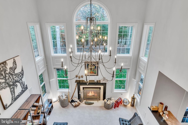 216 Pelagic Ln, Solomons, MD 20688 - living area featuring a towering ceiling, a chandelier, a lit fireplace, and carpet flooring