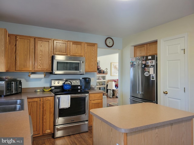 kitchen with dark hardwood / wood-style flooring, stainless steel appliances, and sink