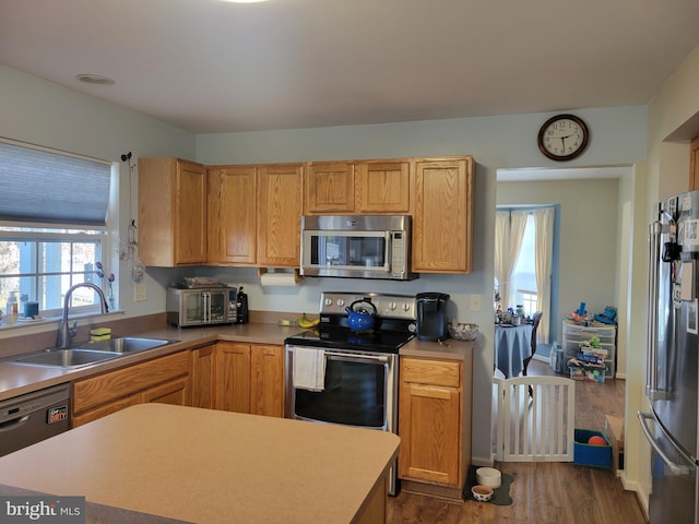 kitchen featuring sink, appliances with stainless steel finishes, and dark wood-type flooring