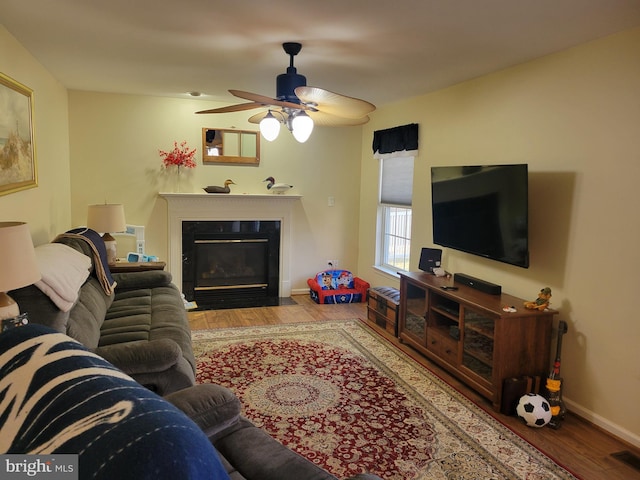 living room featuring ceiling fan and hardwood / wood-style floors