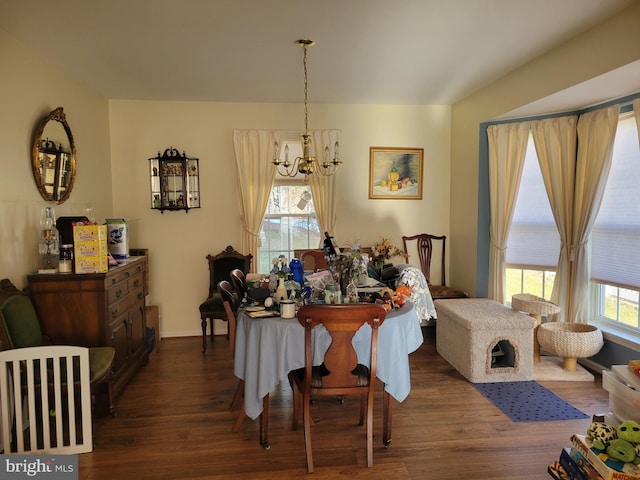 dining area featuring an inviting chandelier and dark wood-type flooring