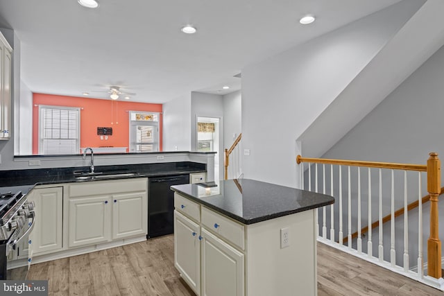 kitchen featuring dishwasher, a center island, sink, high end stainless steel range oven, and light hardwood / wood-style flooring