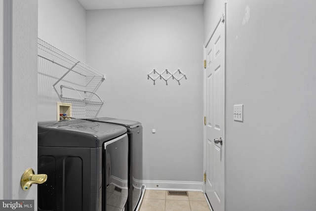 washroom with light tile patterned flooring and washer and dryer