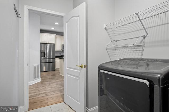 laundry area featuring washer / dryer and light hardwood / wood-style floors