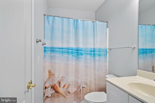 bathroom with vanity, curtained shower, and toilet