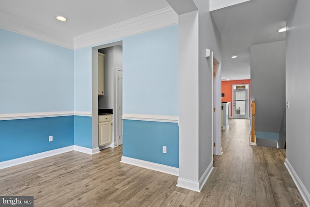 hallway featuring light hardwood / wood-style floors and crown molding