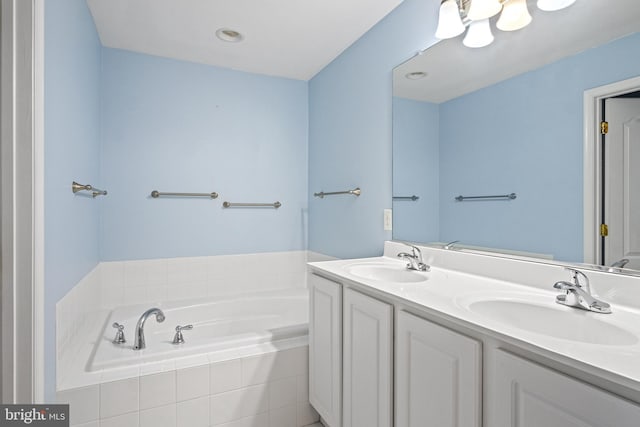 bathroom featuring vanity and tiled tub