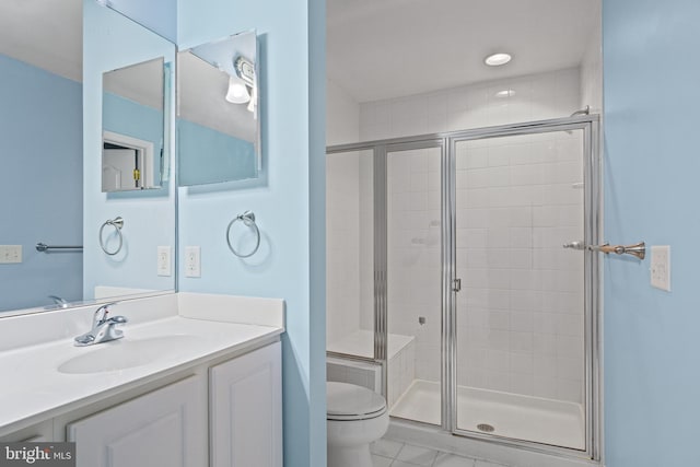 bathroom with tile patterned floors, vanity, an enclosed shower, and toilet