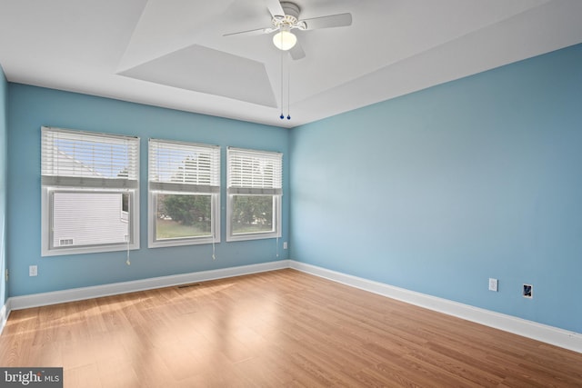 empty room featuring a wealth of natural light, light hardwood / wood-style flooring, and ceiling fan