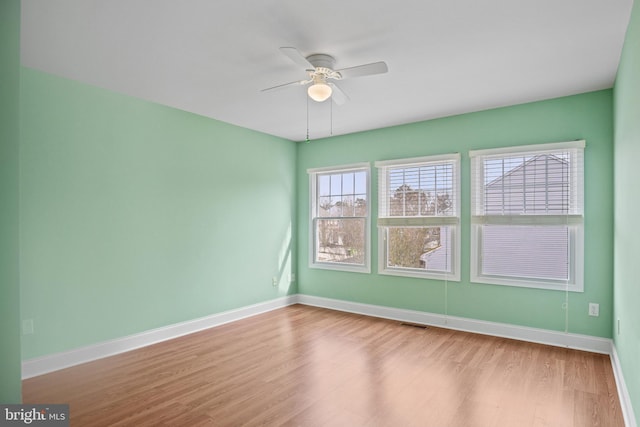 empty room with ceiling fan and light hardwood / wood-style flooring