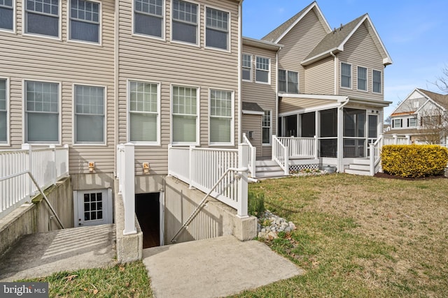 view of front of house with a sunroom and a front yard