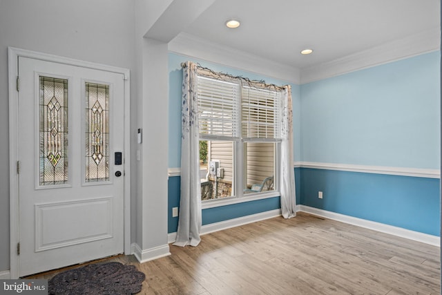 entrance foyer with light hardwood / wood-style floors and crown molding