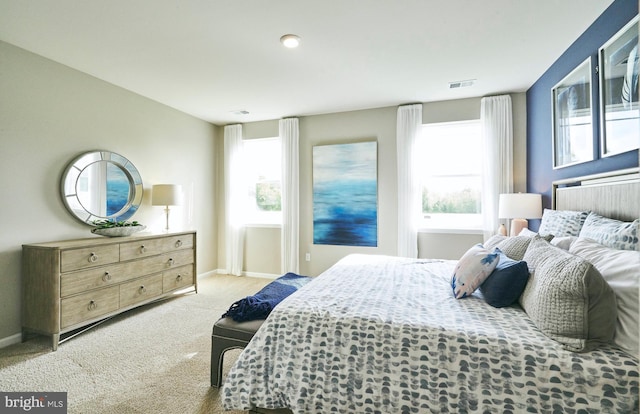 bedroom with light carpet and multiple windows