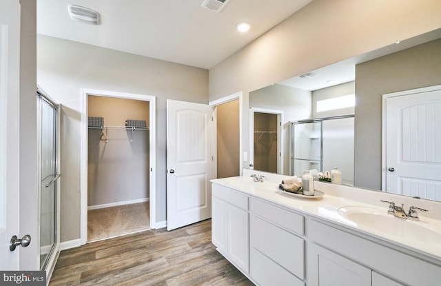 bathroom featuring hardwood / wood-style flooring, vanity, and a shower with shower door