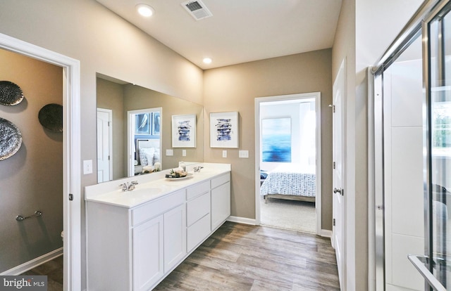 bathroom featuring hardwood / wood-style flooring, vanity, and a shower with shower door