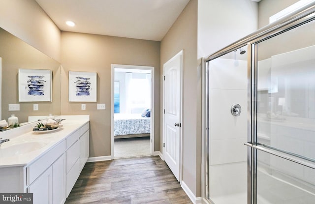 bathroom with a shower with shower door, wood-type flooring, and vanity