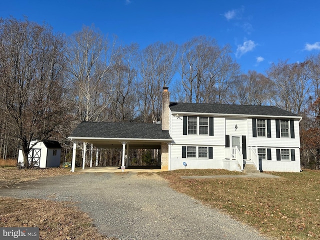 bi-level home featuring a carport, a storage unit, and a front yard