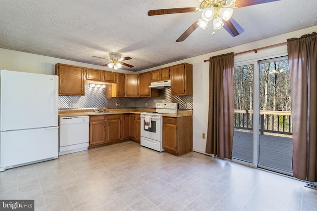 kitchen featuring sink, a textured ceiling, white appliances, decorative backsplash, and ceiling fan with notable chandelier