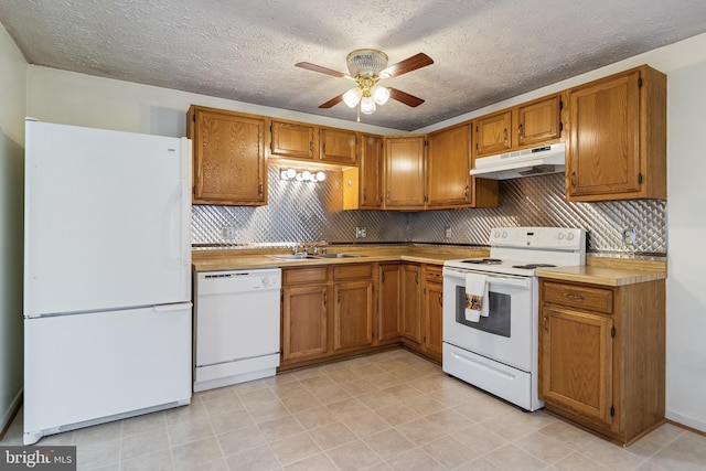 kitchen featuring white appliances, sink, ceiling fan, decorative backsplash, and a textured ceiling