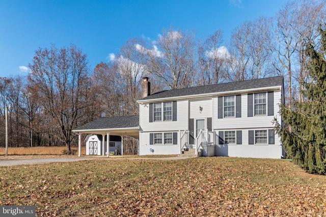 bi-level home featuring a carport and a front yard