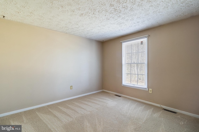 empty room with carpet and a textured ceiling