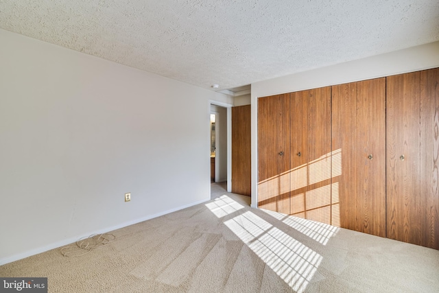 carpeted spare room with a textured ceiling