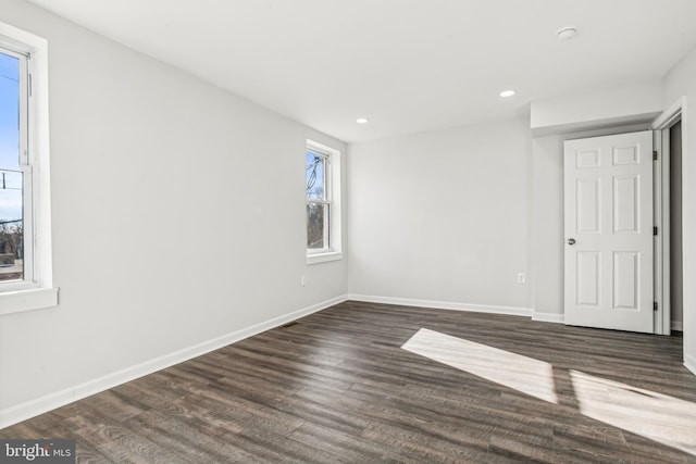 unfurnished room with dark hardwood / wood-style flooring