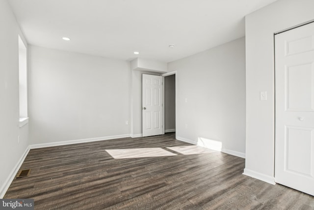 unfurnished room with dark hardwood / wood-style flooring