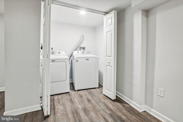 clothes washing area featuring washer and clothes dryer and hardwood / wood-style flooring