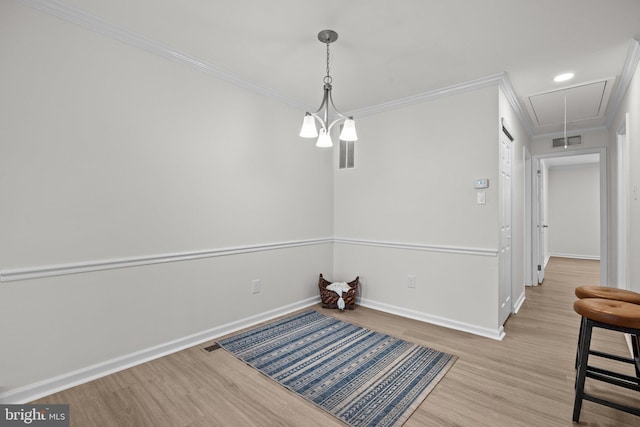 dining area featuring visible vents, ornamental molding, wood finished floors, and attic access