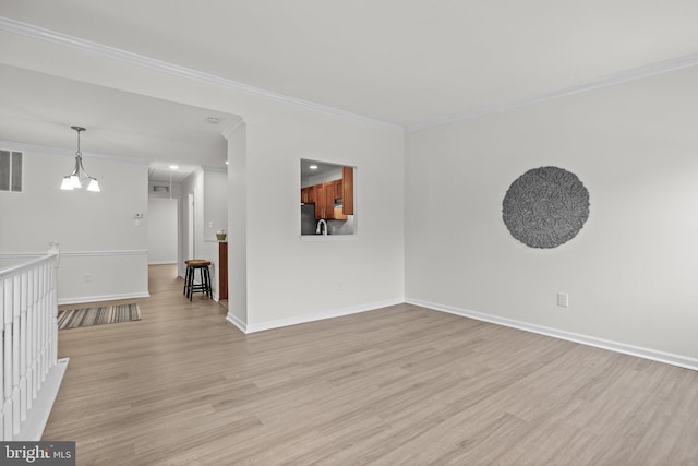 interior space featuring light wood finished floors, visible vents, baseboards, and crown molding