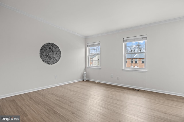 unfurnished room with light wood-style flooring, ornamental molding, and baseboards