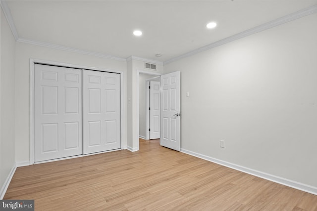 unfurnished bedroom with visible vents, baseboards, light wood-style floors, a closet, and crown molding