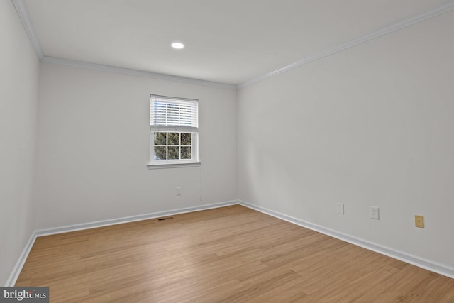 unfurnished room featuring ornamental molding, light wood finished floors, visible vents, and baseboards