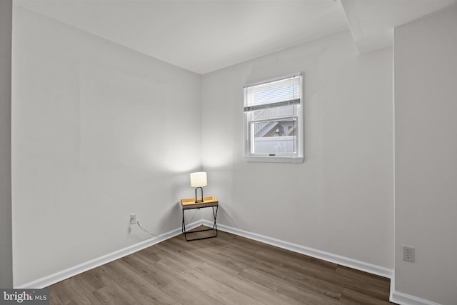 empty room featuring baseboards and wood finished floors