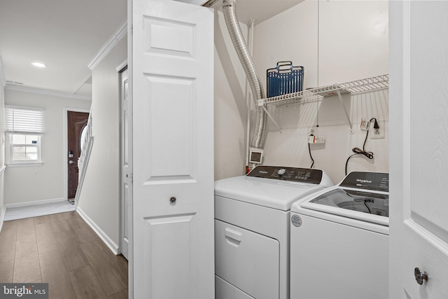 laundry area with dark wood finished floors, ornamental molding, washer and dryer, laundry area, and baseboards