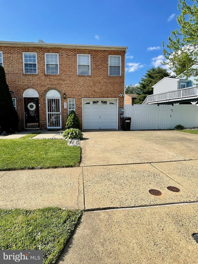 view of front of house with driveway, an attached garage, fence, and brick siding